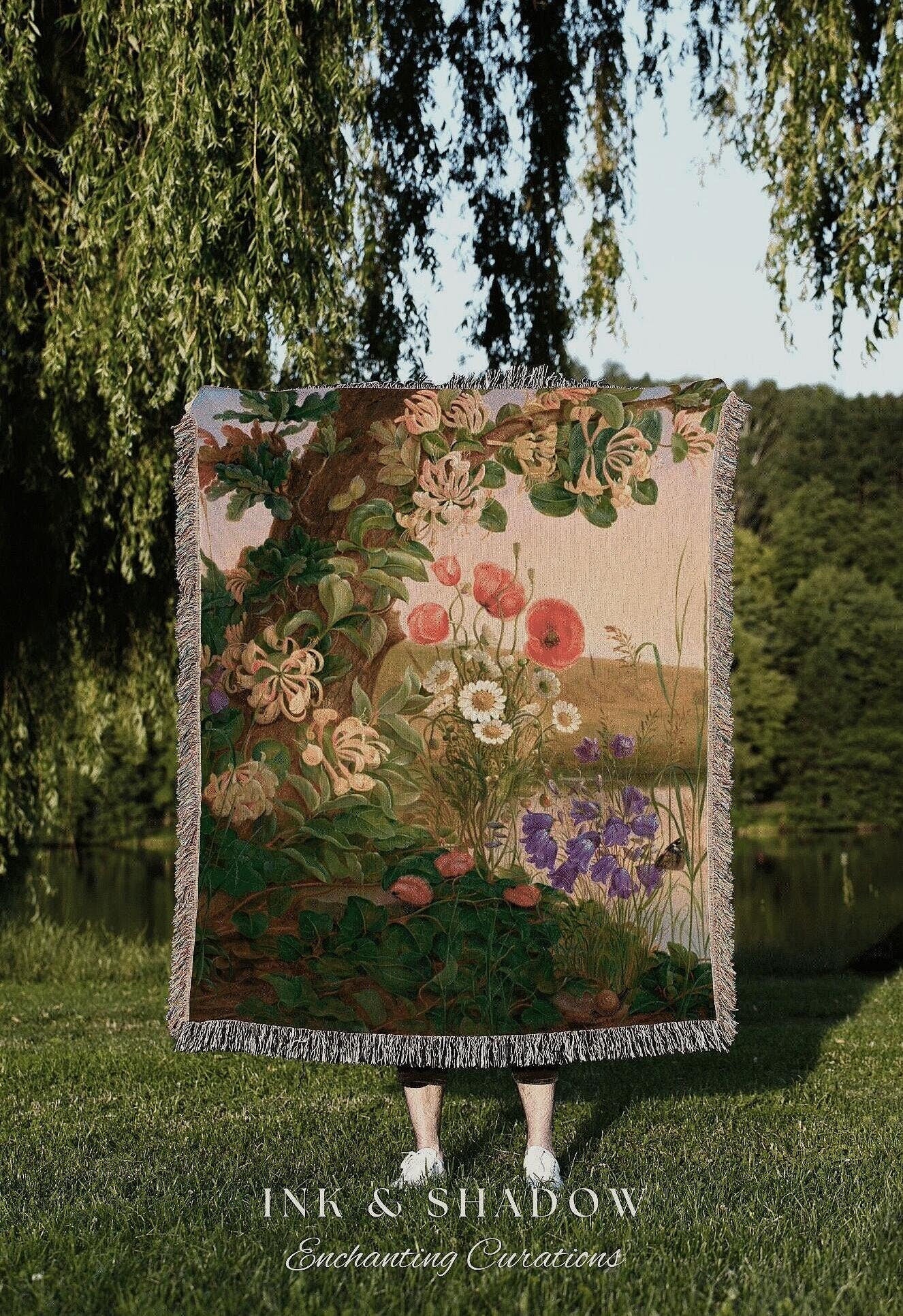 a woman standing under a tree holding a quilt