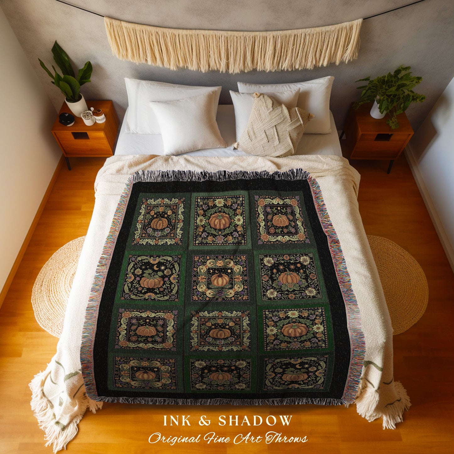 May include: A woven throw blanket with a black background and a green and orange pattern of pumpkins, leaves, and moons. The blanket has a fringe border. The text 'INK & SHADOW Original Fine Art Throws' is printed at the bottom of the blanket.