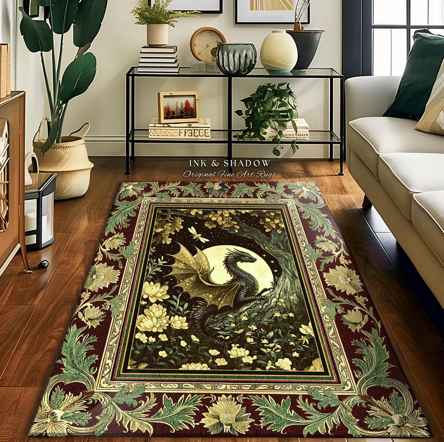 May include: A burgundy, green, and gold area rug with a dragon in a forest scene. The rug has a decorative border with floral designs. The text 'INK & SHADOW Original Fine Art Rugs' is printed on the rug.
