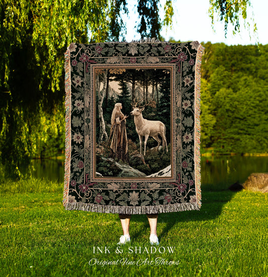 May include: A tapestry throw blanket with a dark green background and a floral border. The center of the tapestry features a woman in a long white dress standing in a forest with a white deer. The tapestry has the words 'Ink & Shadow Original Fine Art Throws' at the bottom.