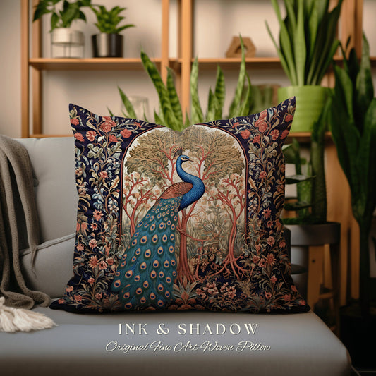 May include: A decorative pillow with a woven tapestry design featuring a peacock standing in a forest scene. The peacock has blue and green feathers. The pillow is navy blue with a red, orange, and green floral border. The text 'INK & SHADOW Original Fine Art Woven Pillow' is printed below the pillow.