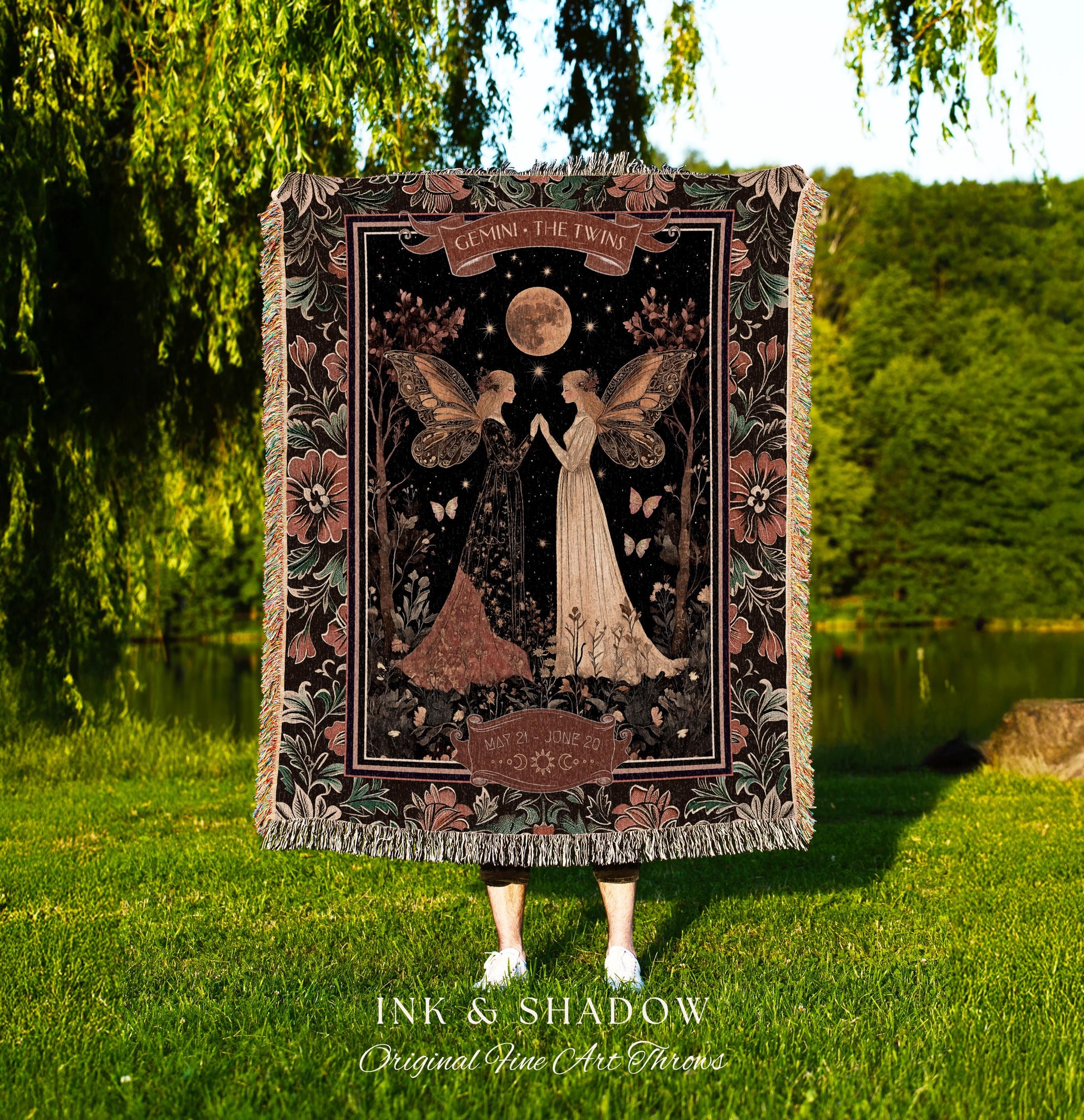 May include: A woven tapestry throw blanket with a dark background featuring two fairies with wings. The fairies are standing in a forest with a full moon and stars in the sky. The text on the blanket reads &#39;Gemini, The Twins&#39; and &#39;May 21st - June 20th&#39;. The blanket has a dark green, black, and brown color scheme with pink flowers on the border.