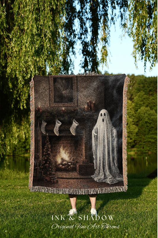 May include: A woven tapestry throw blanket with a dark brown background. The blanket features a fireplace with a fire burning, stockings hanging on the mantle, and a white ghost standing in front of the fireplace. The text &#39;INK & SHADOW Original Fine Art Throws&#39; is printed in white at the bottom of the blanket.