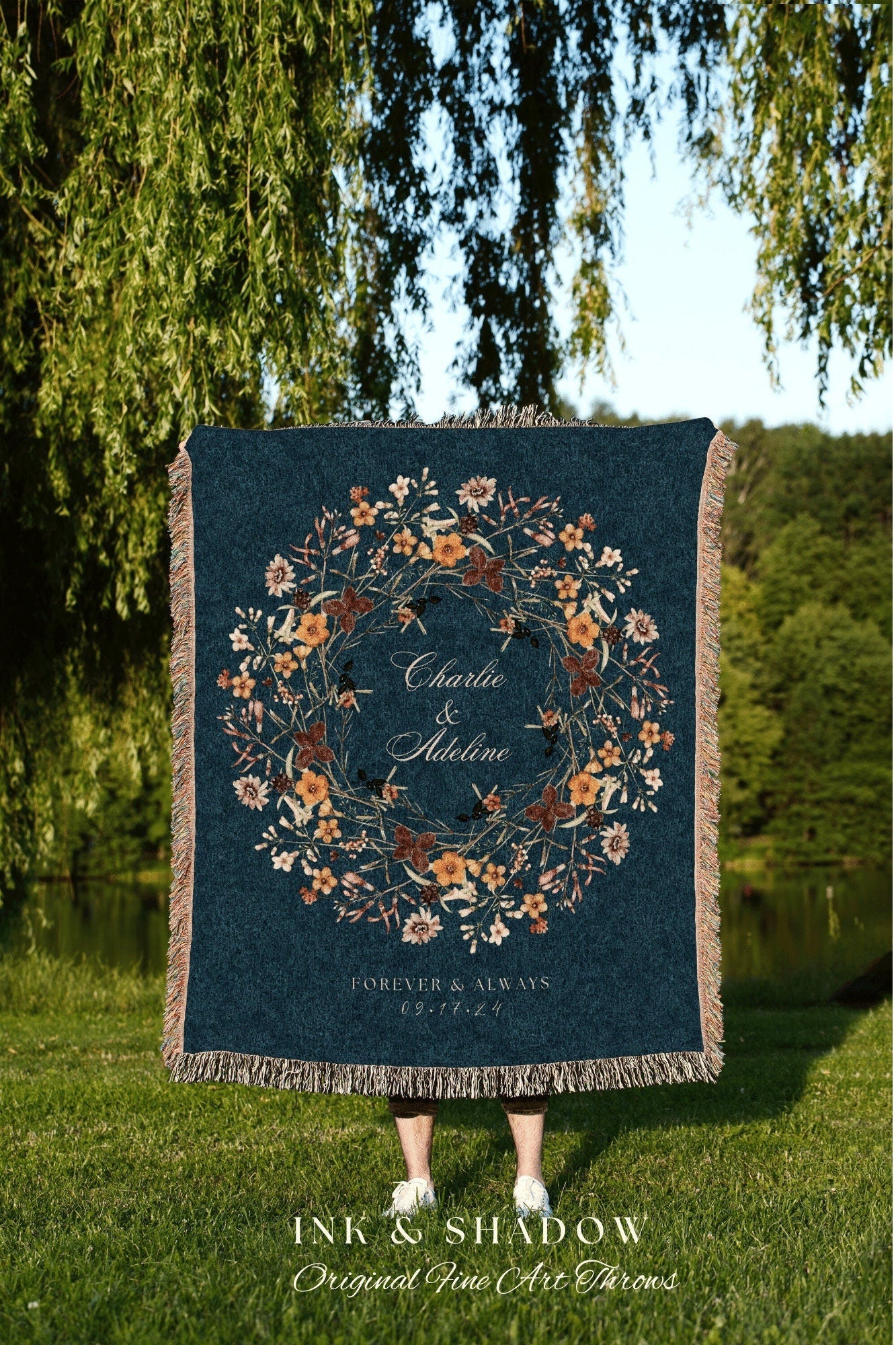 May include: A woven throw blanket with a dark blue background and a floral wreath design in shades of orange, yellow, and brown. The wreath encircles the text 'Charlie & Adeline' and 'FOREVER & ALWAYS 09.17.24'.
