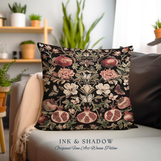 May include: A square throw pillow features a dark background with a repeating pattern of pomegranates, flowers, and butterflies. The pillow is woven with a tapestry-like texture.  The colors are deep reds, pinks, and greens against a black background. The text &#39;INK & SHADOW Original Fine Art Woven Pillow&#39; is displayed below the pillow.
