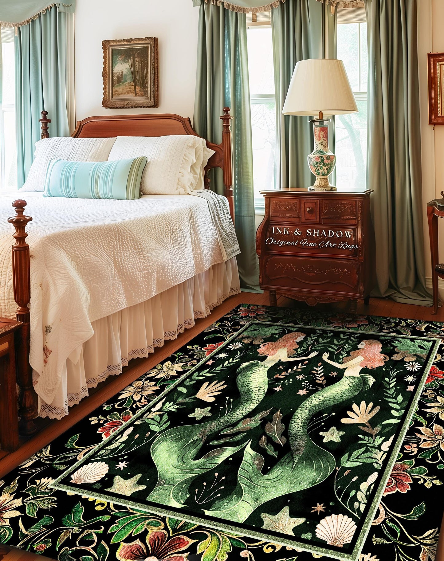 May include: A dark green area rug features two mermaids with flowing tails, surrounded by floral and shell designs. The rug has a black background with gold accents. The text &#39;INK & SHADOW Original Fine Art Rugs&#39; is visible on a wooden nightstand in the background. The rug is displayed in a bedroom setting with a wooden bed and light teal curtains.