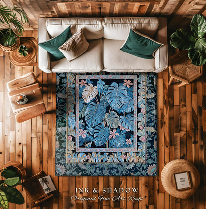 May include: A blue and black rug with a floral pattern. The rug has a border of pink and yellow flowers. The rug is on a wooden floor. The text on the rug reads &#39;INK & SHADOW Original Fine Art Rugs&#39;.