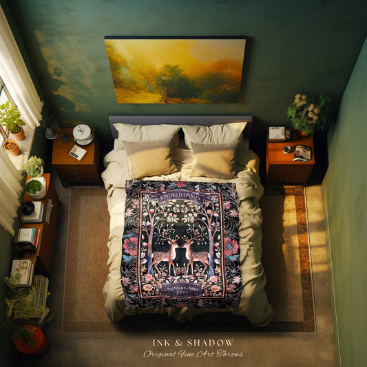 May include: A black throw blanket with a floral design featuring two deer with antlers. The blanket has the words &#39;Kindred Spirits&#39; in a circle at the top and &#39;Dylan & Gabby 2022&#39; at the bottom. The blanket is on a bed with white pillows and a gray headboard. The blanket is part of the &#39;Ink & Shadow Original Fine Art Throws&#39; collection.