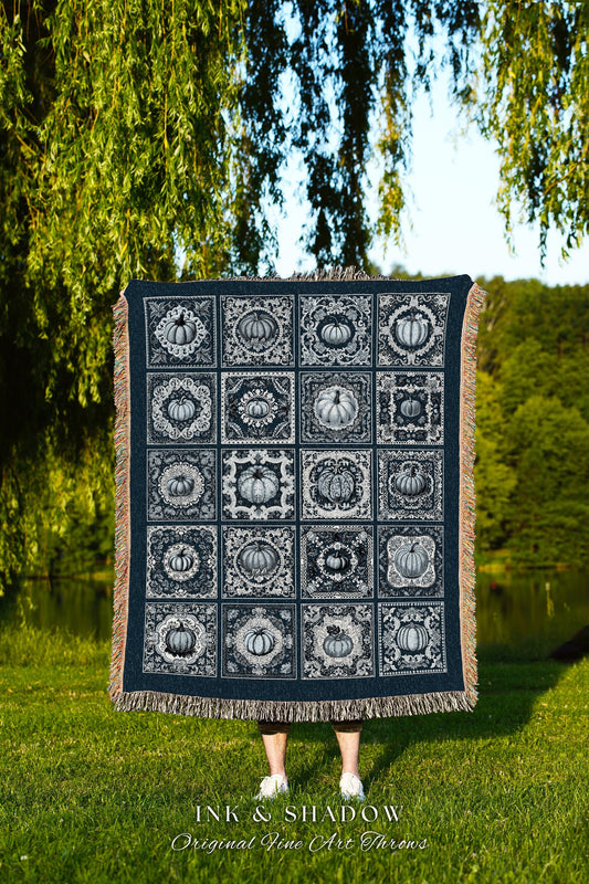 May include: A woven throw blanket with a navy blue background and a white design of repeating pumpkin patterns in ornate frames. The text &#39;INK & SHADOW Original Fine Art Throws&#39; is at the bottom of the blanket.