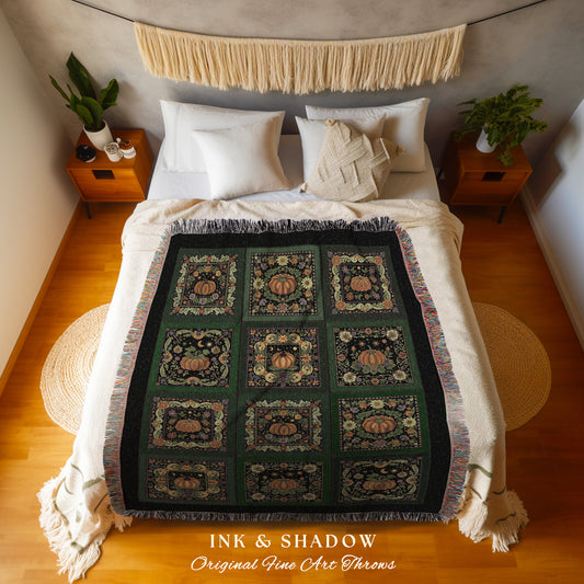 May include: A woven throw blanket with a black background and a green and orange pattern of pumpkins, leaves, and moons. The blanket has a fringe border. The text &#39;INK & SHADOW Original Fine Art Throws&#39; is printed at the bottom of the blanket.