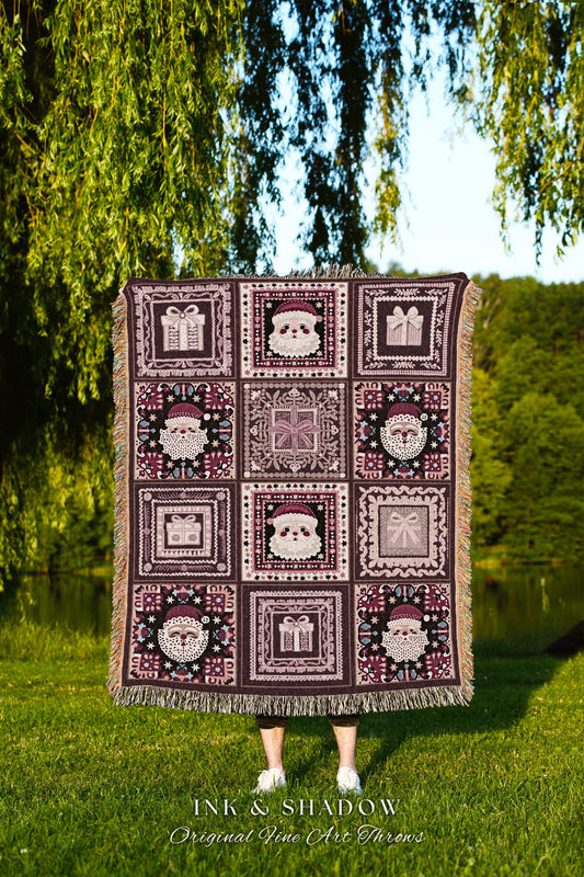 May include: A woven Christmas throw blanket features a patchwork design with repeating squares. Each square shows a Santa Claus face, a gift box, or a decorative motif. The blanket is in shades of burgundy, cream, and dark brown. The text &#39;INK & SHADOW Original Fine Art Throws&#39; is visible at the bottom.