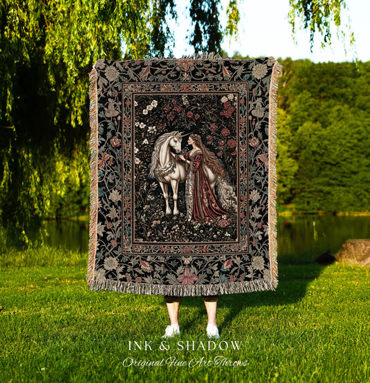 May include: A tapestry throw blanket with a black background and a floral design. The center of the tapestry features a white unicorn and a woman in a red dress. The text &#39;INK & SHADOW Original Fine Art Throws&#39; is at the bottom of the image.