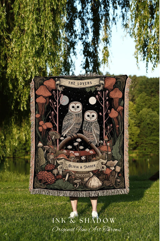 May include: A woven tapestry with a black background featuring two owls perched on a branch with a full moon behind them. The tapestry has a border of mushrooms and flowers. The text &#39;THE LOVERS&#39; is at the top of the tapestry. The text &#39;OLIVIA & TANNER&#39; is at the bottom of the tapestry.