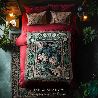 May include: A green and black throw blanket with a floral pattern. The blanket has a fringe border and is displayed on a red velvet bed. The blanket has the text &#39;INK & SHADOW Original Fine Art Throws&#39; at the bottom.