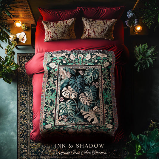 May include: A green and black throw blanket with a floral pattern. The blanket has a fringe border and is displayed on a red velvet bed. The blanket has the text &#39;INK & SHADOW Original Fine Art Throws&#39; at the bottom.