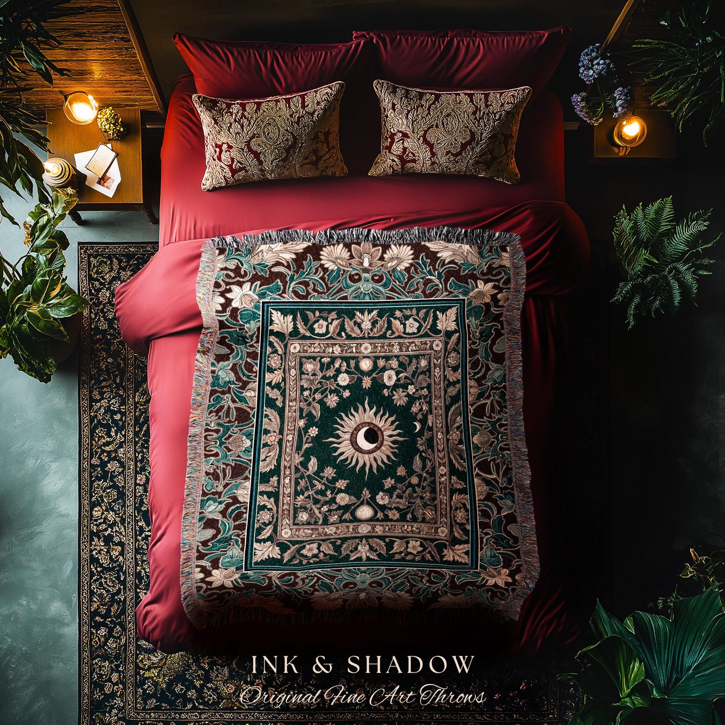 May include: A green and brown tapestry throw blanket with a sun and moon design. The throw blanket is on a red bed with two pillows. The throw blanket has a fringe border and the text &#39;INK & SHADOW Original Fine Art Throws&#39; is at the bottom of the image.