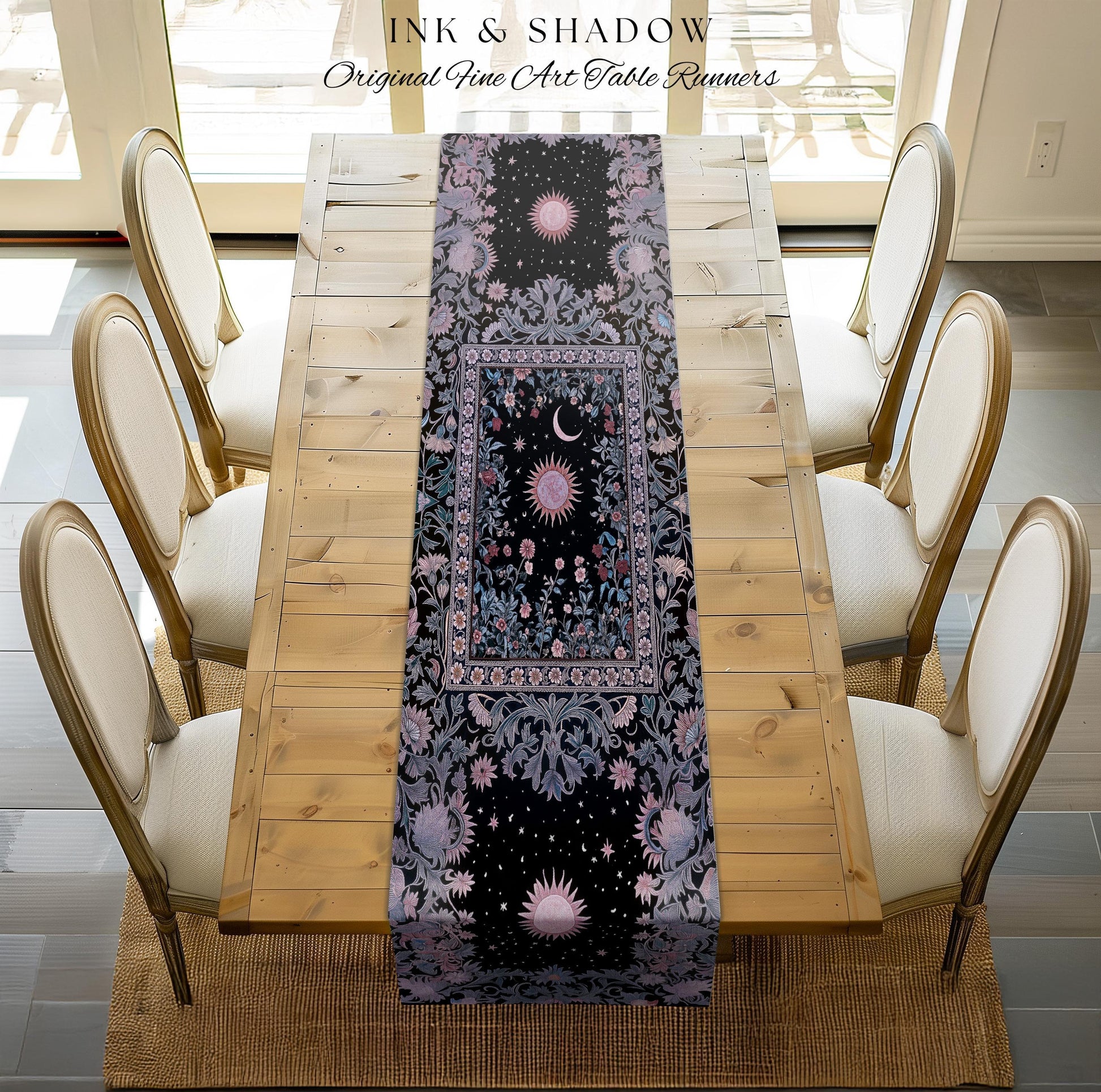 May include: A black table runner with a celestial design featuring suns, moons, and stars. The runner has a floral border in shades of purple and blue. The words 'INK & SHADOW Original Fine Art Table Runners' are at the top. The runner is placed on a wooden table with six chairs.