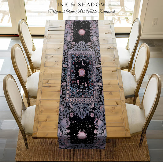 May include: A black table runner with a celestial design featuring suns, moons, and stars. The runner has a floral border in shades of purple and blue. The words 'INK & SHADOW Original Fine Art Table Runners' are at the top. The runner is placed on a wooden table with six chairs.