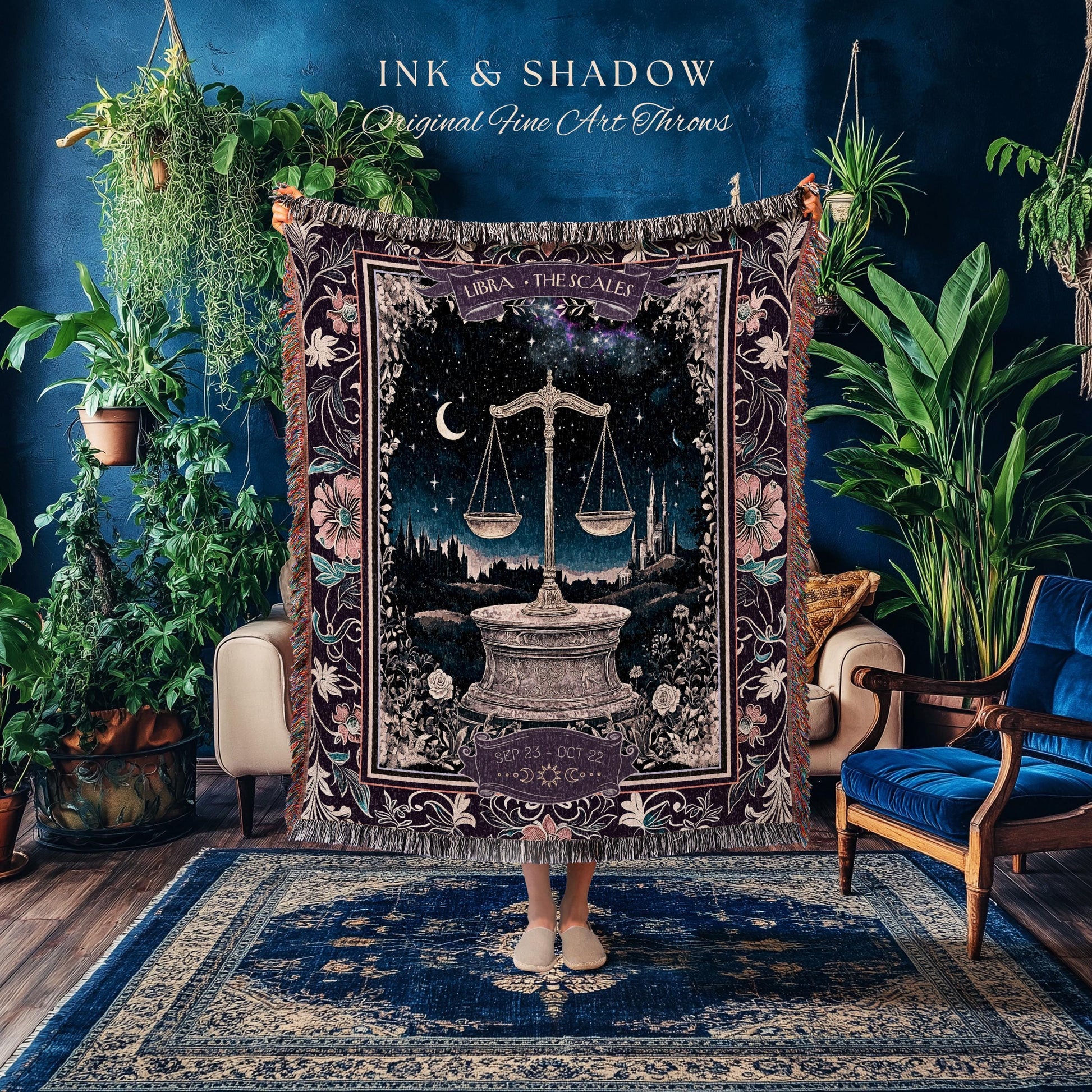 May include: A woven tapestry throw blanket with a dark purple background and intricate floral designs. The center of the blanket features a stylized image of a scale with a crescent moon and stars in the background. The text 'LIBRA THE SCALES' is above the scale and the text 'SEP 23 - OCT 22' is below the scale.