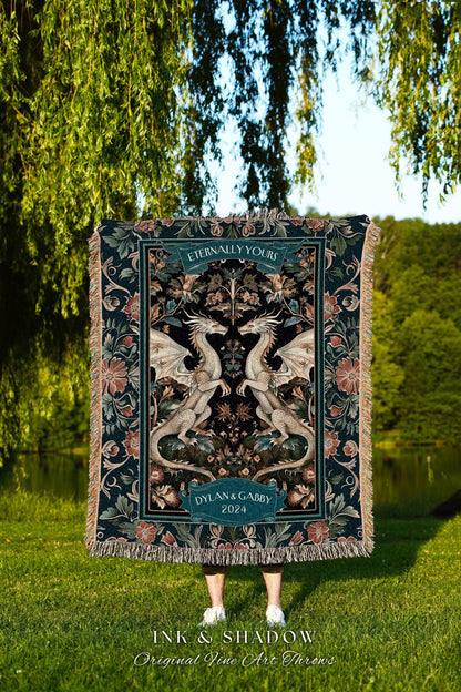 May include: A decorative throw blanket featuring a symmetrical design of two white dragons facing each other. The blanket has a dark teal background with floral and scrollwork details. The text "Eternally Yours" and "Dylan & Gabby 2024" are displayed on the blanket.