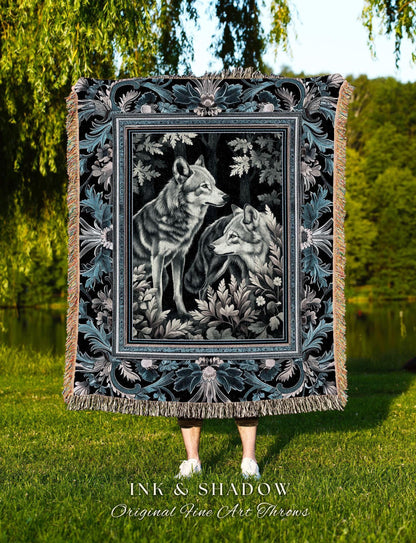 May include: A black and teal throw blanket featuring a framed image of two wolves in a forest setting. The blanket has a decorative border with floral and leaf patterns and a fringed edge. The text "INK & SHADOW Original Fine Art Throws" is at the bottom.