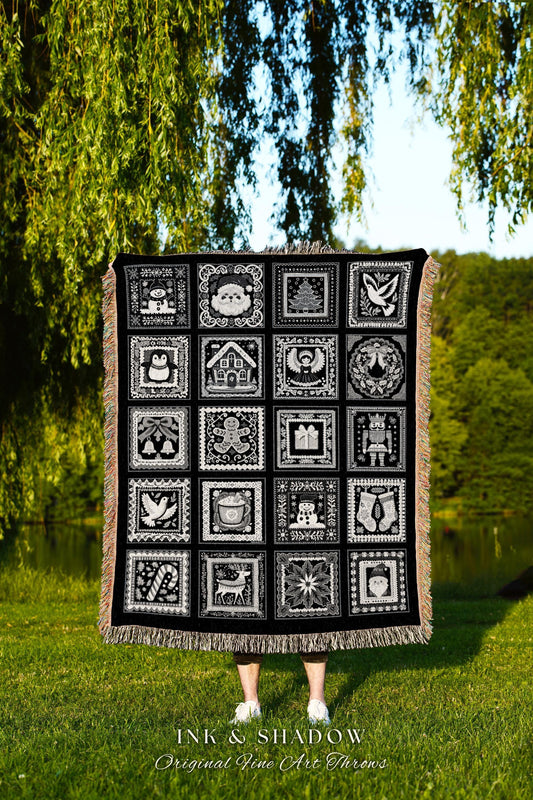 May include: A black woven throw blanket with a white design of 16 squares. Each square has a different Christmas-themed image, including a snowman, a gingerbread man, a Christmas tree, a stocking, a reindeer, a candy cane, and an angel. The text 'INK & SHADOW Original Fine Art Throws' is printed below the blanket.