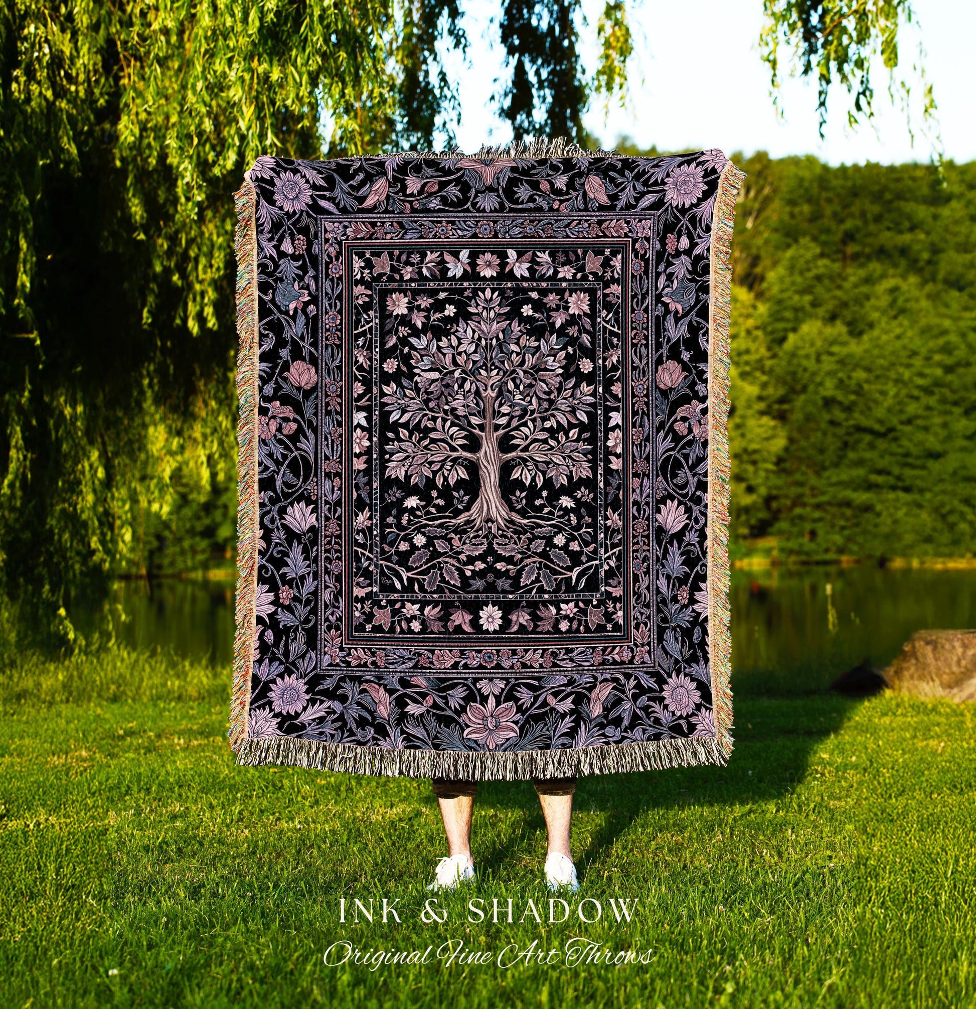 May include: A black and purple throw blanket with a tree of life design. The blanket has a floral border and fringe. The text "INK & SHADOW Original Fine Art Throws" is at the bottom.