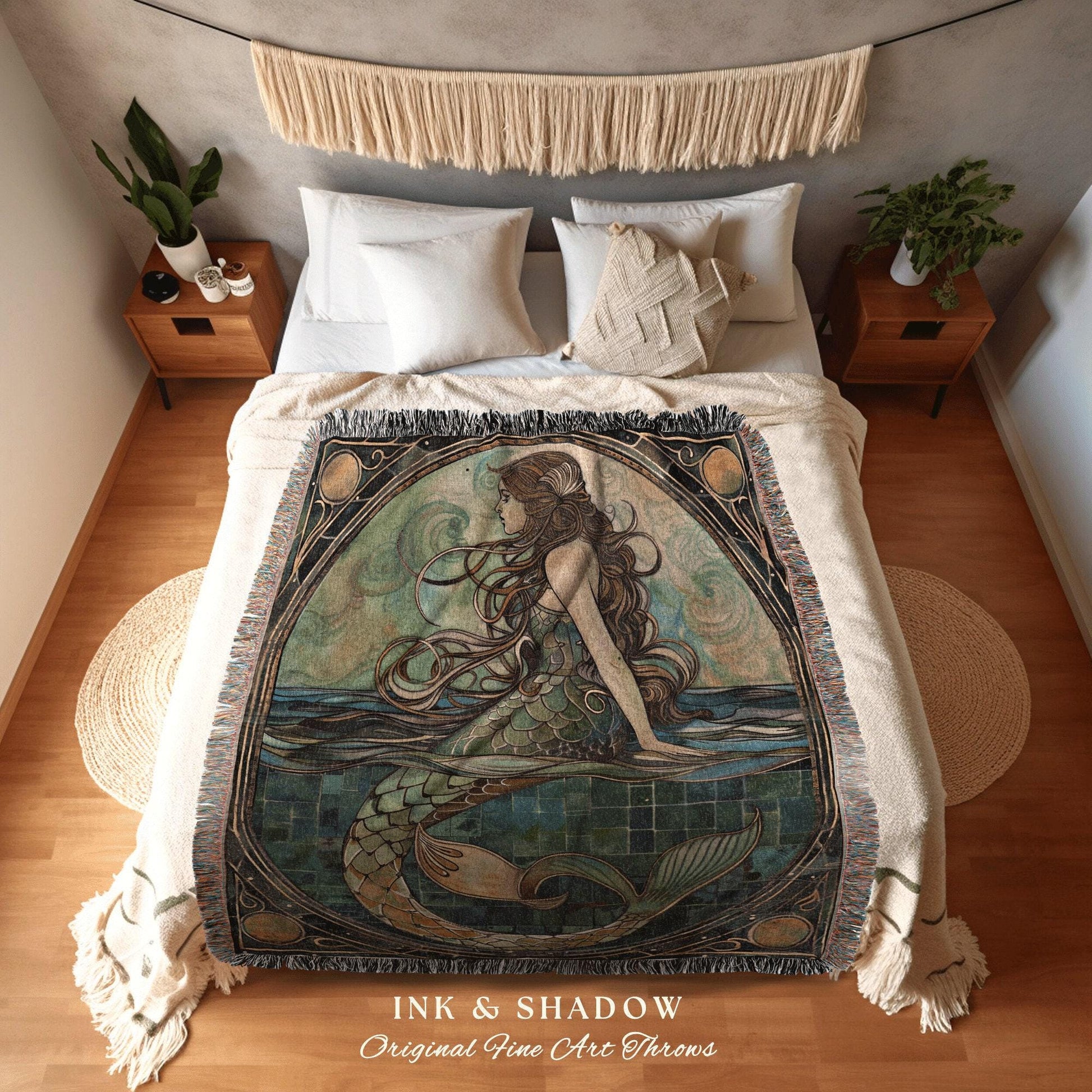 May include: A woven tapestry throw blanket featuring a mermaid with long flowing hair sitting on a tiled surface with a blue and green color scheme. The blanket has a dark brown border with gold accents and the words 'INK & SHADOW Original Fine Art Throws' at the bottom.