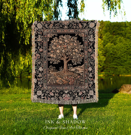 May include: A black throw blanket with a detailed tree design, framed by floral patterns and fringe. The tree has a large trunk and branches with leaves. The blanket has the text "INK & SHADOW Original Fine Art Throws".