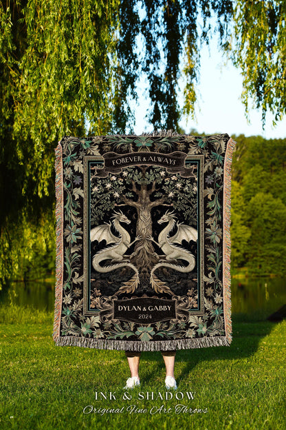 May include: A black woven tapestry throw blanket with a dark green and gold design featuring two dragons flanking a tree with the text "Forever & Always" and "Dylan & Gabby 2024". The throw blanket is held in front of a person standing on green grass.