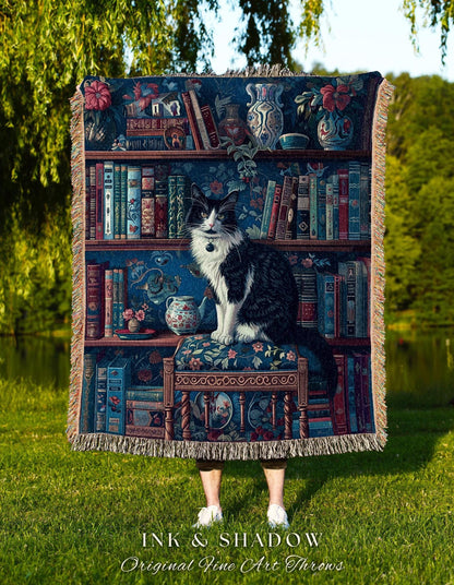 May include: A tapestry throw blanket featuring a detailed bookshelf design with a black and white cat perched on a decorative chair. The throw has a fringed edge and the text "INK & SHADOW Original Fine Art Throws" at the bottom.