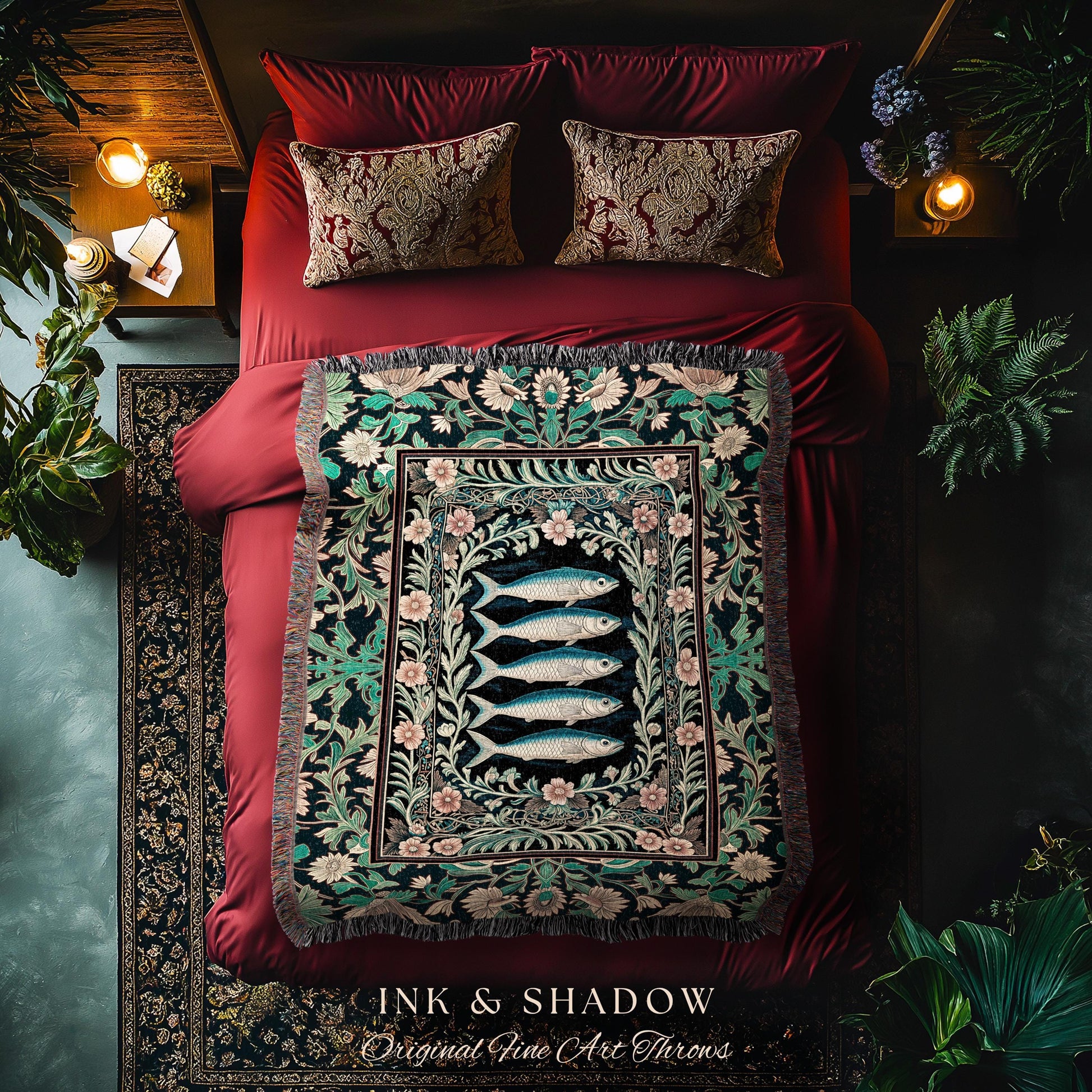 May include: A decorative throw blanket with a fish design, displayed on a red bed with matching pillows. The blanket features a black background with a floral border and four blue fish. The text "INK & SHADOW Original Fine Art Throws" is visible.