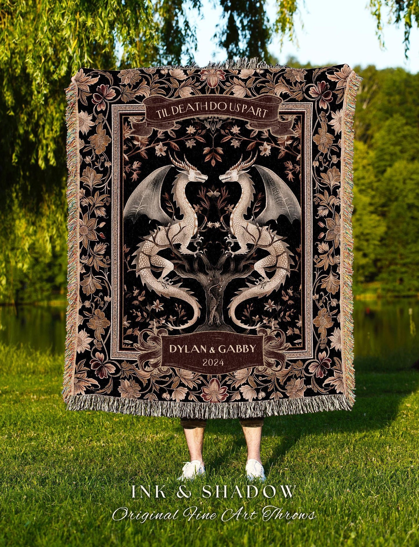 May include: A black throw blanket with a detailed floral and dragon design. The blanket features the text "TIL DEATH DO US PART" and "DYLAN & GABBY 2024". The bottom of the blanket has a fringe. The text "INK & SHADOW Original Fine Art Throws" is at the bottom.
