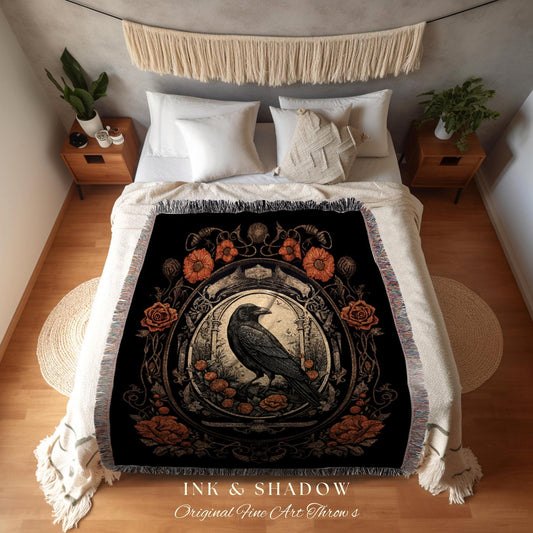 May include: Black throw blanket featuring a detailed illustration of a raven within a floral frame. The design includes orange flowers and roses. The text "INK & SHADOW Original Fine Art Throws" is at the bottom.