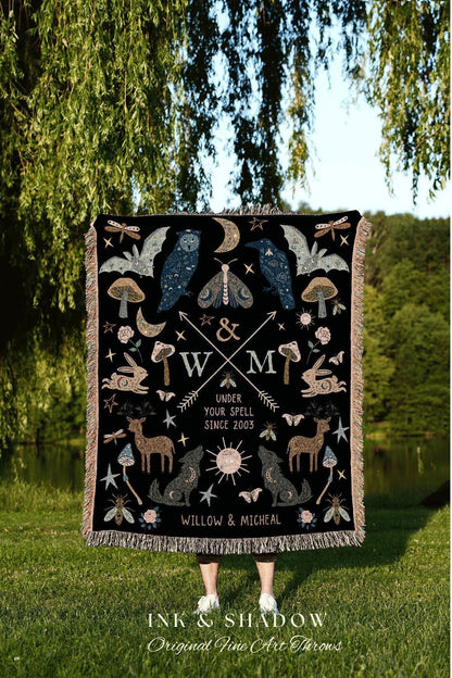 May include: Black throw blanket with a whimsical design featuring an owl, raven, moth, deer, wolf, and other celestial and forest elements. The blanket has a fringed edge and includes the text "UNDER YOUR SPELL SINCE 2003" and "WILLOW & MICHEAL".