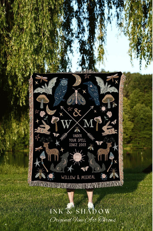 May include: Black throw blanket with a whimsical design featuring an owl, raven, moth, deer, wolf, and other celestial and forest elements. The blanket has a fringed edge and includes the text "UNDER YOUR SPELL SINCE 2003" and "WILLOW & MICHEAL".