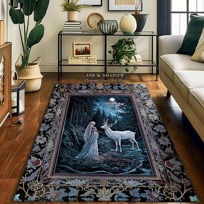 May include: A black and blue area rug with a detailed floral border. The center of the rug features a scene of a woman in a white dress standing in a forest with a white deer. The text "Ink & Shadow Original Fine Art Rugs" is printed on the rug.