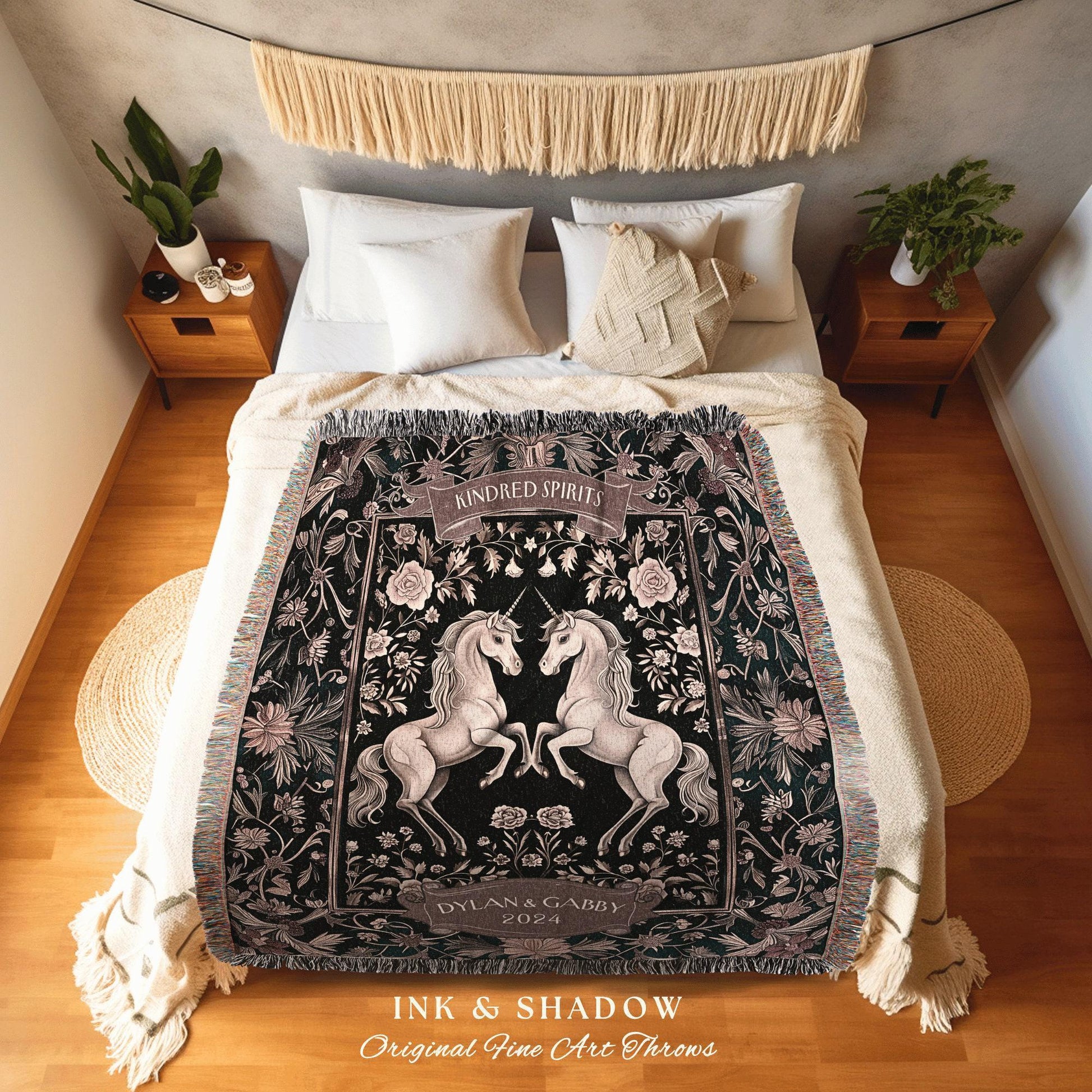 May include: A black throw blanket with a floral and unicorn design. The blanket features two white unicorns facing each other, with the words "Kindred Spirits" and "Dylan & Gabby 2024" on it. The text "INK & SHADOW Original Fine Art Throws" is at the bottom.