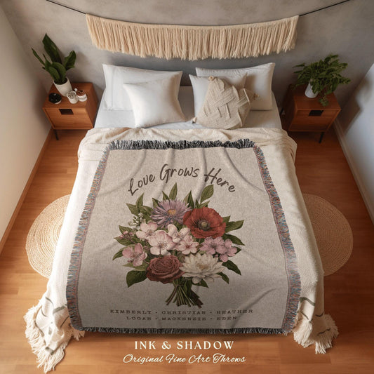 May include: A beige throw blanket with a floral bouquet design and the text "Love Grows Here." The bouquet features red, pink, and purple flowers. The blanket has a fringed edge and the names Kimberly, Christian, Heather, Logan, Mackenzie, and Eden.