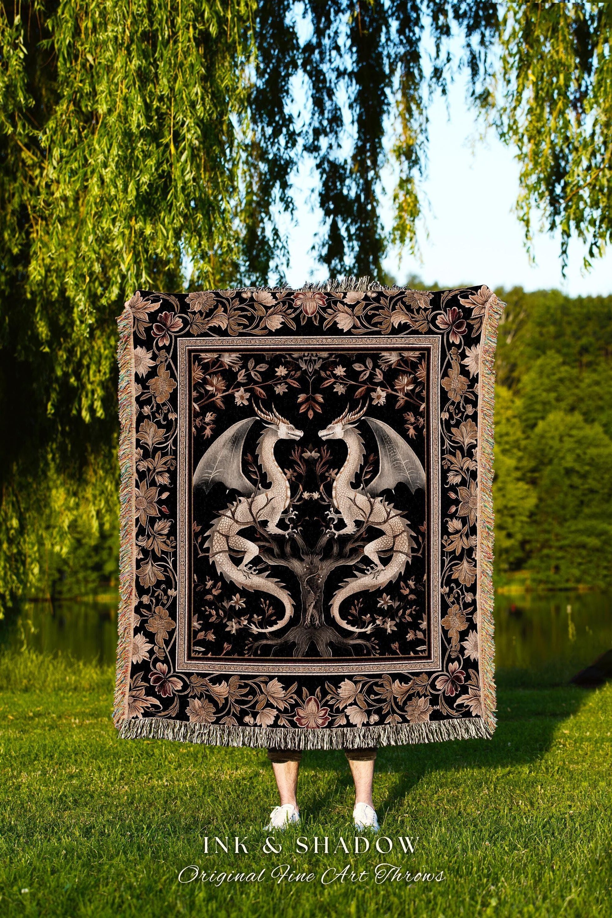 May include: A black throw blanket with a detailed design featuring two white dragons facing each other, set against a black background. The blanket has a floral border and fringe. The text "INK & SHADOW Original Fine Art Throws" is at the bottom.