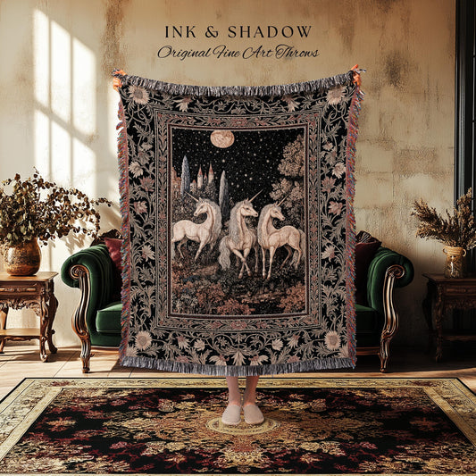 May include: A black tapestry throw blanket with a detailed illustration of three unicorns under a starry night sky. The blanket has a fringed edge and floral border. Text at the top reads "INK & SHADOW Original Fine Art Throws."