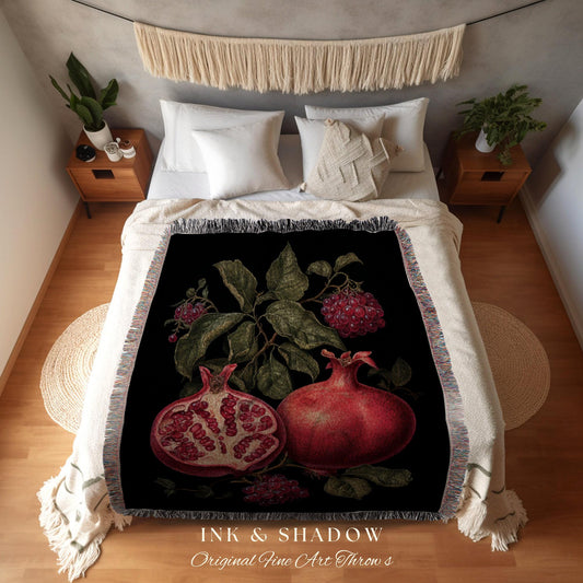 May include: Black throw blanket featuring a botanical illustration of pomegranates and foliage. The design includes a whole pomegranate and a sliced one, showcasing the seeds. The text "INK & SHADOW Original Fine Art Throws" is printed at the bottom.