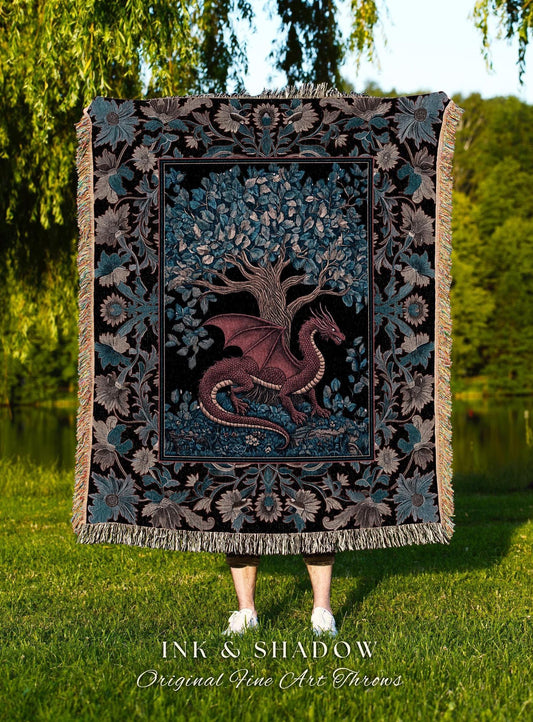 May include: A tapestry throw blanket featuring a dragon and tree design. The dragon is maroon, with a black background and a floral border in teal and gray. The blanket has a fringed edge. The text "INK & SHADOW Original Fine Art Throws" is at the bottom.