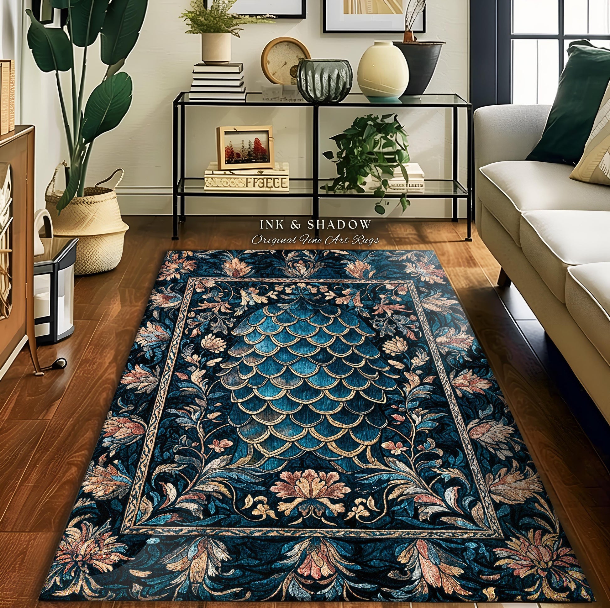 May include: A teal blue area rug with a floral pattern and a large, stylized, teal blue and gold scale pattern in the center. The rug has a dark blue background and a light pink floral pattern around the edges. The rug is on a hardwood floor in a living room setting.