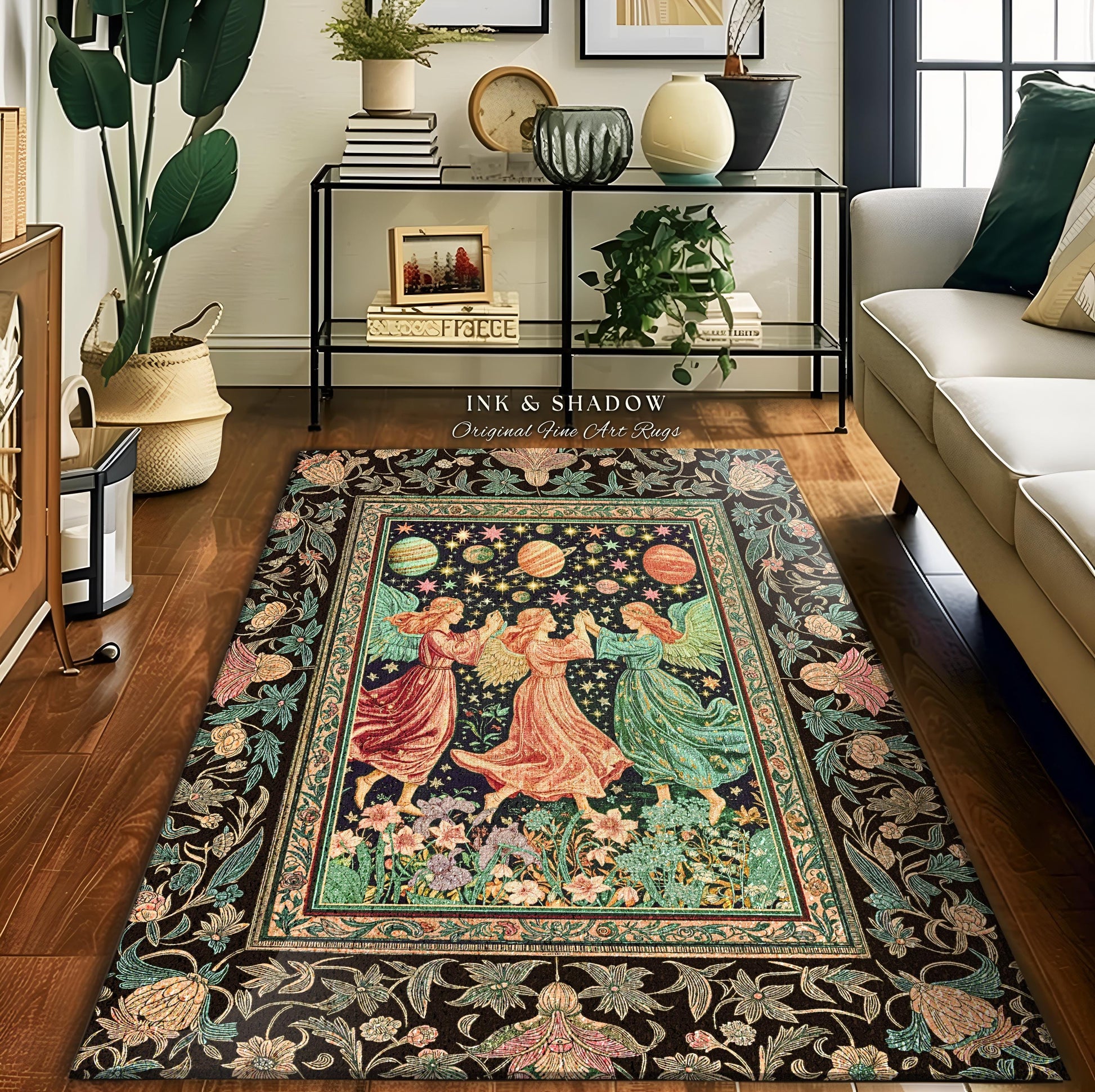 May include: A rectangular area rug with a dark background and a central image of three figures in flowing gowns dancing under planets and stars. The rug has a floral border and the text "INK & SHADOW Original Fine Art Rugs".