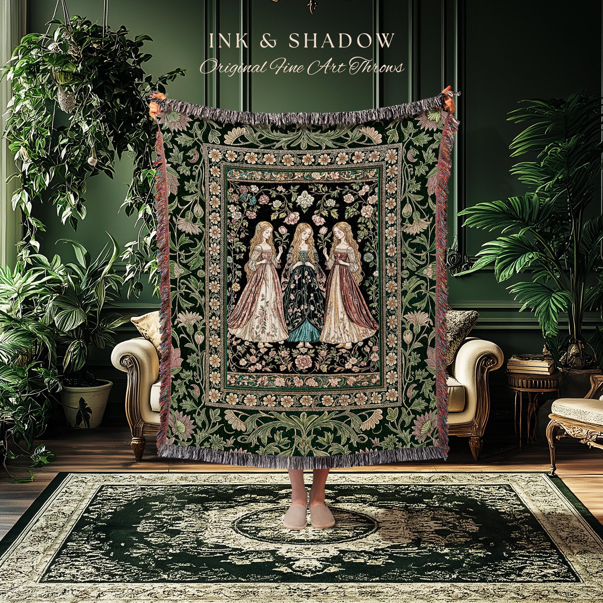 May include: A decorative tapestry throw featuring three women in long gowns, set against a floral background. The throw has a dark green border with fringe and the text "INK & SHADOW Original Fine Art Throws".