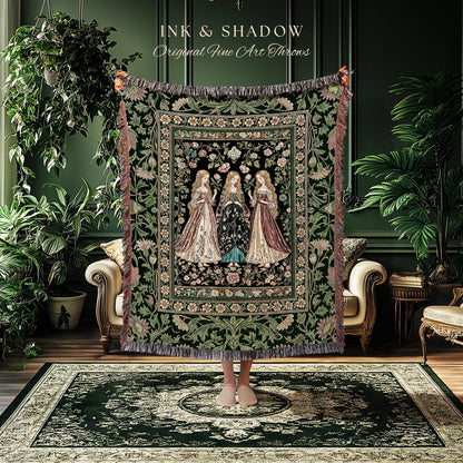 May include: A decorative tapestry throw featuring three women in long gowns, set against a floral background. The throw has a dark green border with fringe and the text "INK & SHADOW Original Fine Art Throws".