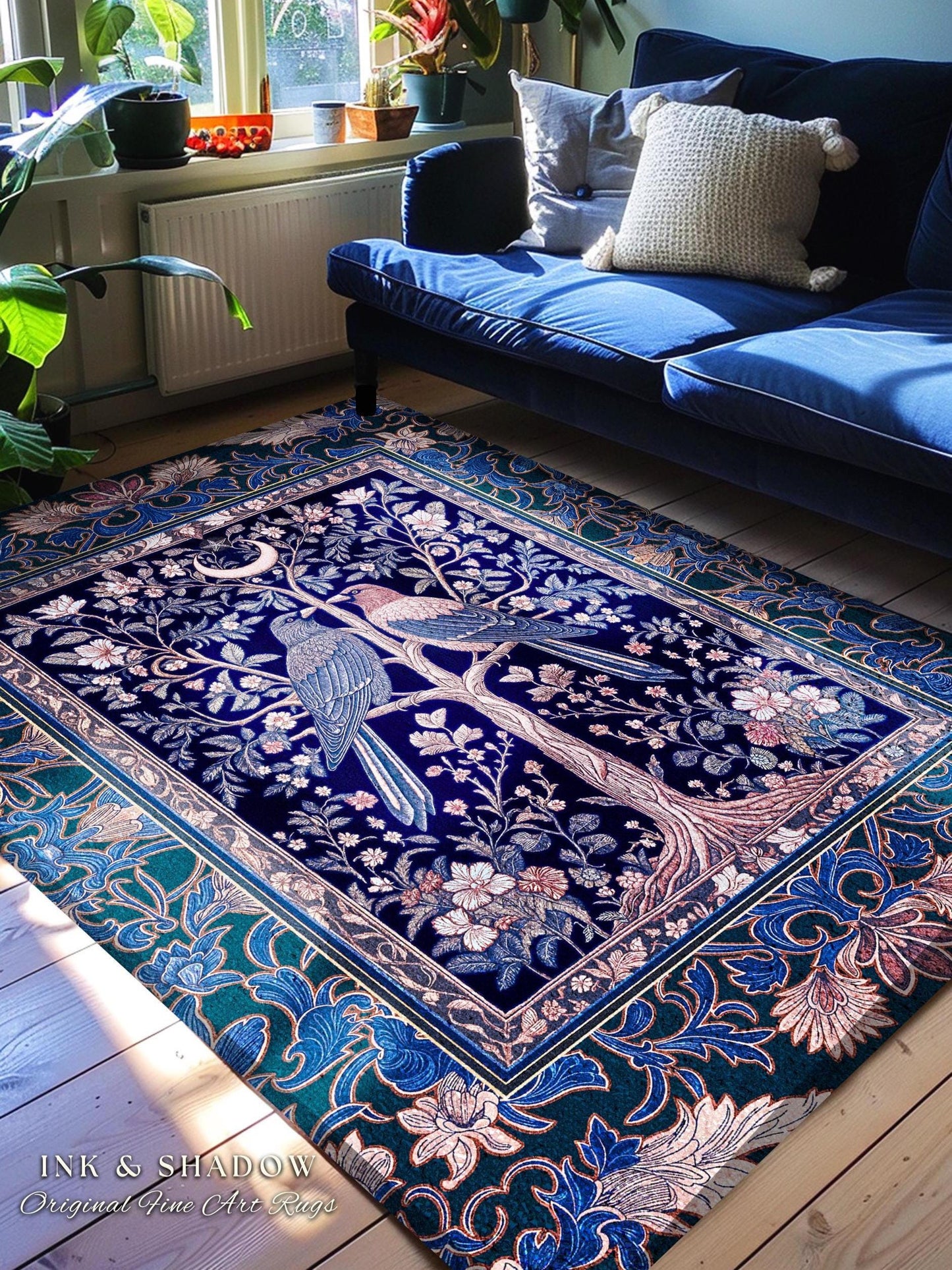 May include: A rectangular, dark blue rug with a detailed tree and bird design. The rug features a border with floral patterns in shades of blue, green, and pink. The text "INK & SHADOW Original Fine Art Rugs" is visible.