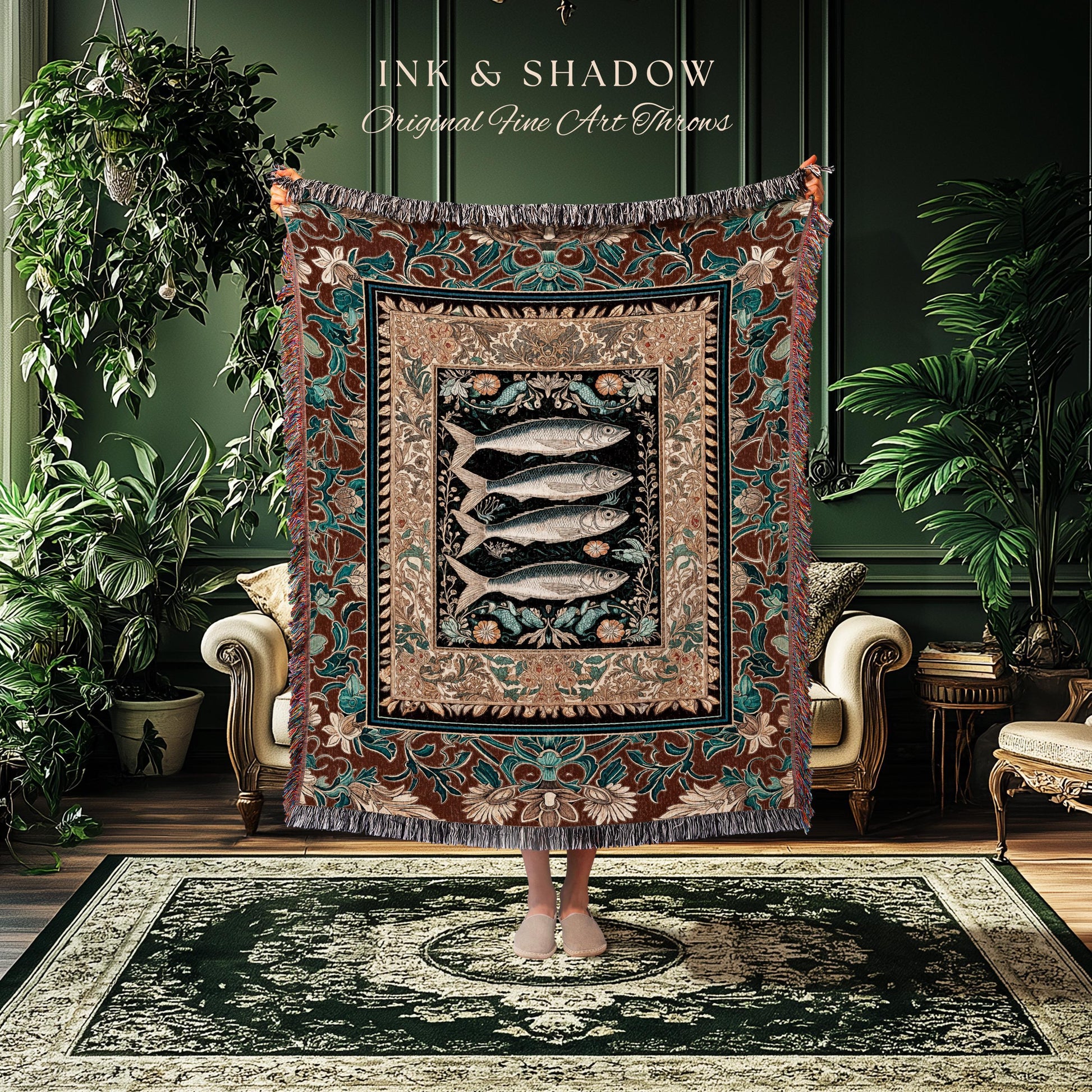 May include: A decorative throw blanket with a fish design. The blanket features a central image of four fish on a black background, framed by floral and geometric patterns in shades of brown, teal, and beige. The text "INK & SHADOW Original Fine Art Throws" is at the top.
