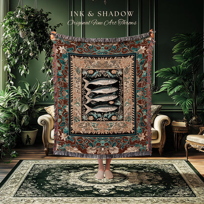 May include: A decorative throw blanket with a fish design. The blanket features a central image of four fish on a black background, framed by floral and geometric patterns in shades of brown, teal, and beige. The text "INK & SHADOW Original Fine Art Throws" is at the top.